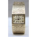 A 9ct gold ladies wristwatch by Bueche Girod c.1967, the rectangular gold, bark effect dial with