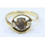 A 14ct yellow gold ring, the central stone, possibly a cognac smoky quartz, flanked by two white