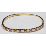 A David Morris 18ct yellow gold, diamond and pink sapphire hinged bangle, claw-set with 11-RBC