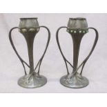 After Archibald Knox (1864-1933) a matched pair of Tudric twin handled pewter vases, whiplash