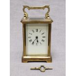 A French brass carriage clock with white enamel dial and Roman Numerals, platform escapement and "