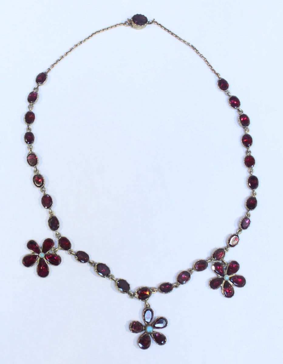 A George III gold, garnet and turquoise necklace modelled as twenty-six flat-back oval garnets,