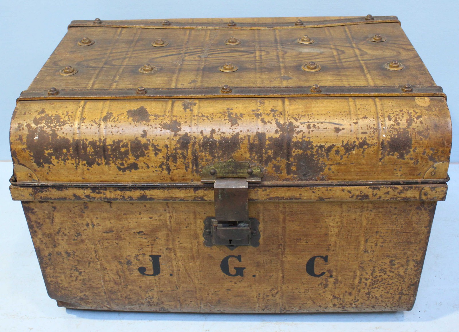 A large metal trunk with initials "J.G.C" written to front, painted to simulate wood, 69cm wide 46cm