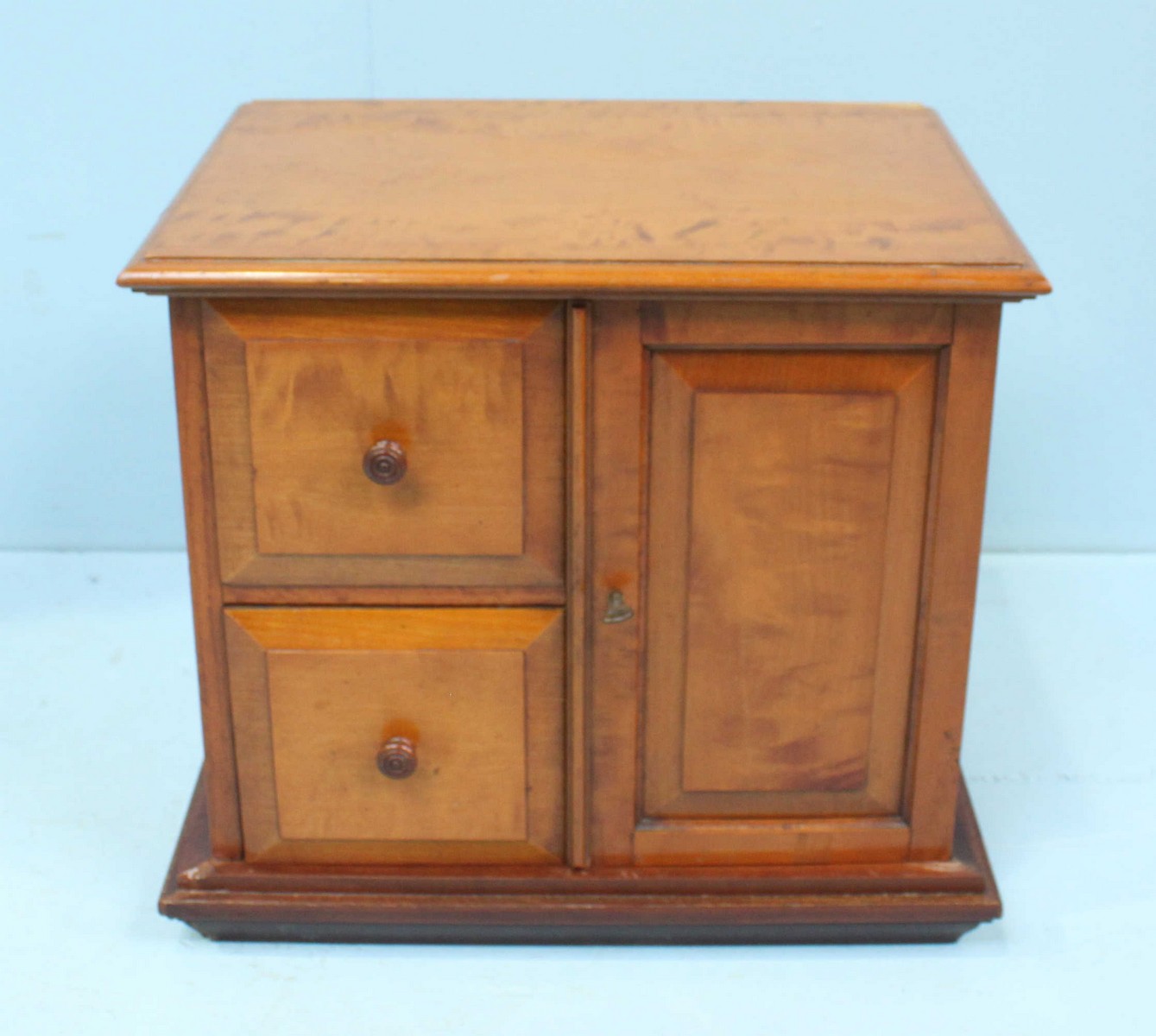 A Satinwood table top storage cabinet consisting 2 square drawers and 1 cupboard door, 34cm high