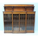 An early 20th Century mahogany central breakfront bookcase, with raised superstructure above an