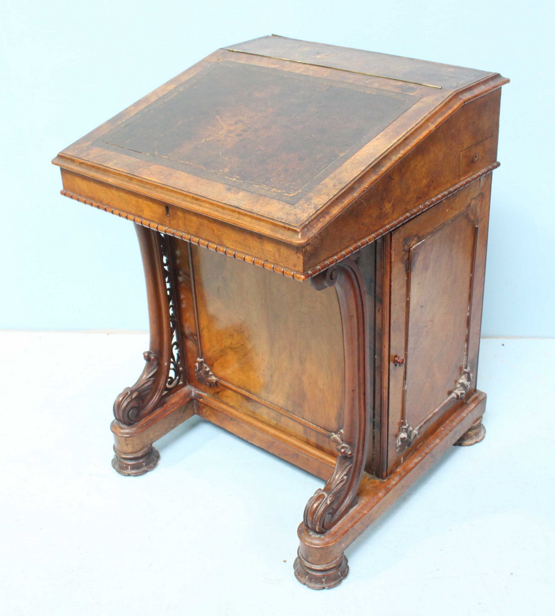 A Victorian walnut Davenport desk, the hinged, sloped front with gilt tooled leather scribe, opening