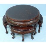 A Chinese carved circular occasional table, together with small segmented tables that fit below.