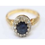 An 18ct yellow gold Sapphire and Diamond ring, the centrally set oval Sapphire surrounded by 12