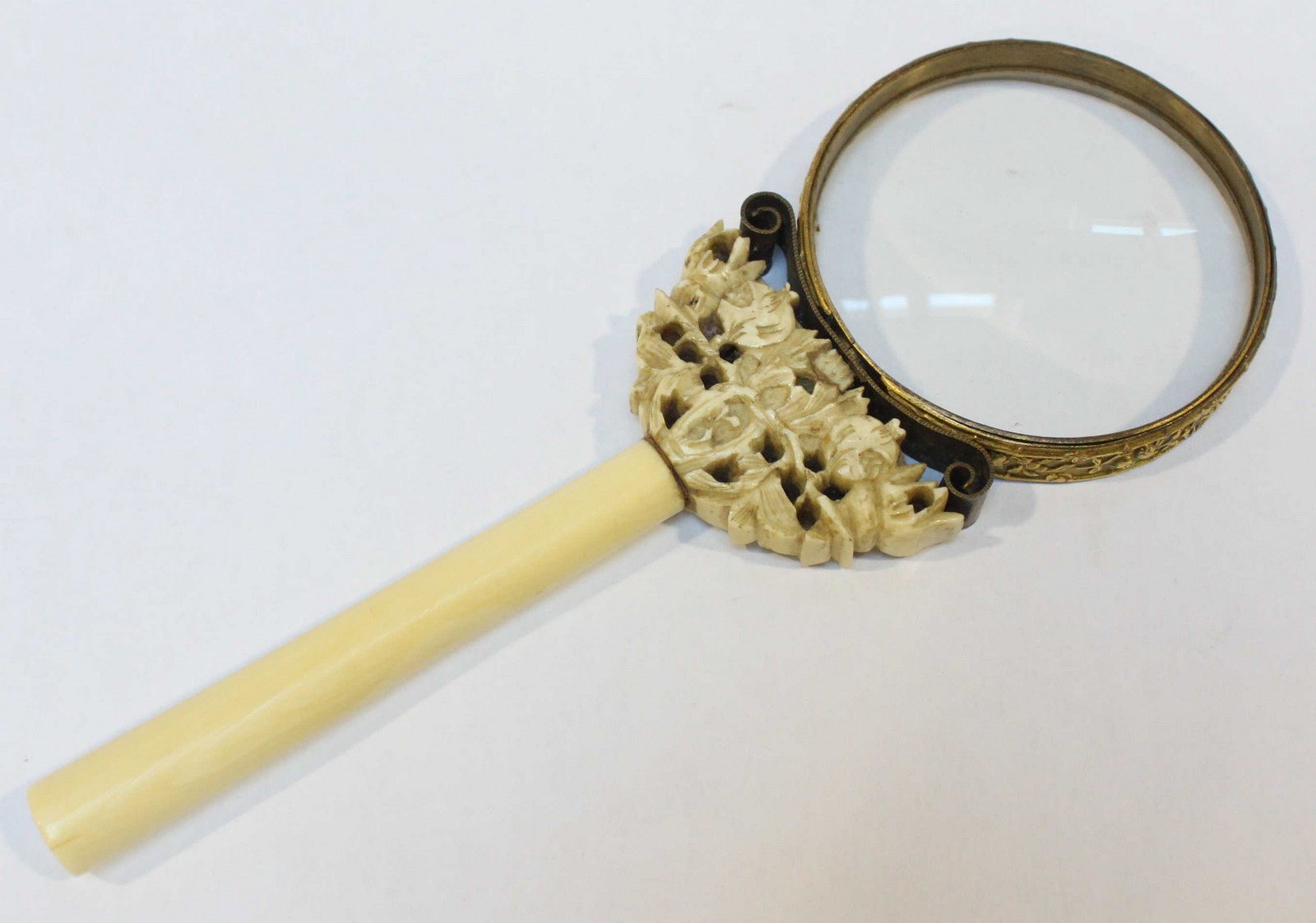 A late 19th / early 20th century gilt metal and carved ivory magnifying glass, 19cm long