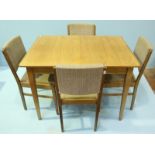 A 1960's/70's Gordon Russell walnut extending dining table with additional leaf and raised on