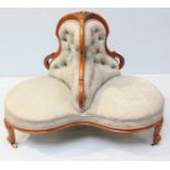 A Victorian walnut conversation sofa of trefoil form, with floral carved decoration, button back,