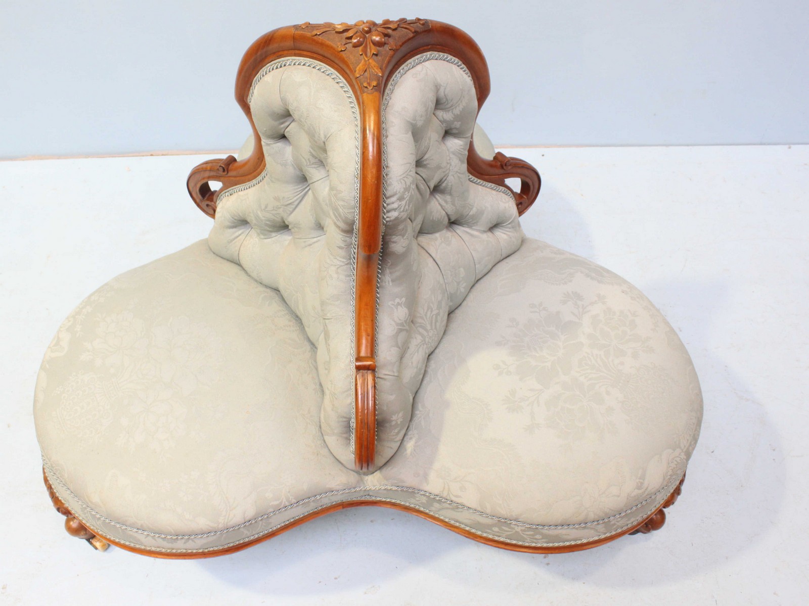 A Victorian walnut conversation sofa of trefoil form, with floral carved decoration, button back, - Image 2 of 3