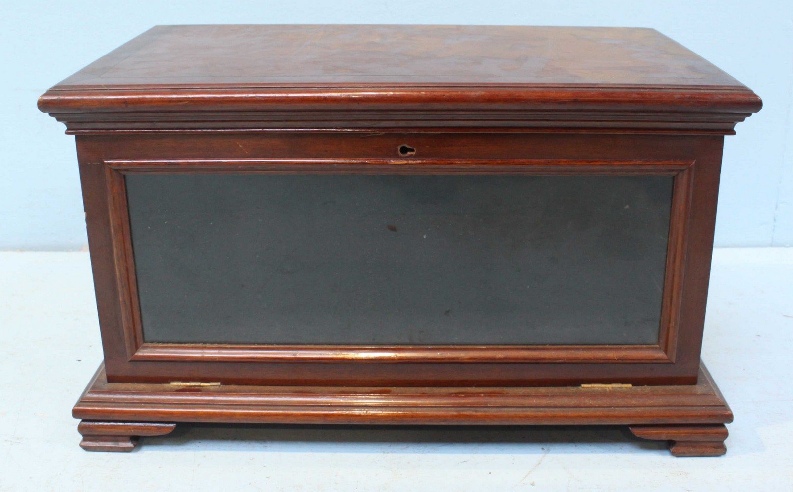 A late 19th/early 20th century mahogany tabletop bookcase, with shaped cornice above a hinged,