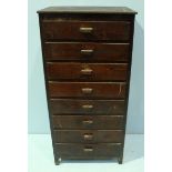 A painted pine narrow chest of eight short drawers with shaped pulls and raised on square