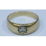 A gents 9ct gold ring, gypsy set with a solitaire diamond in ornately carved surround. Gross