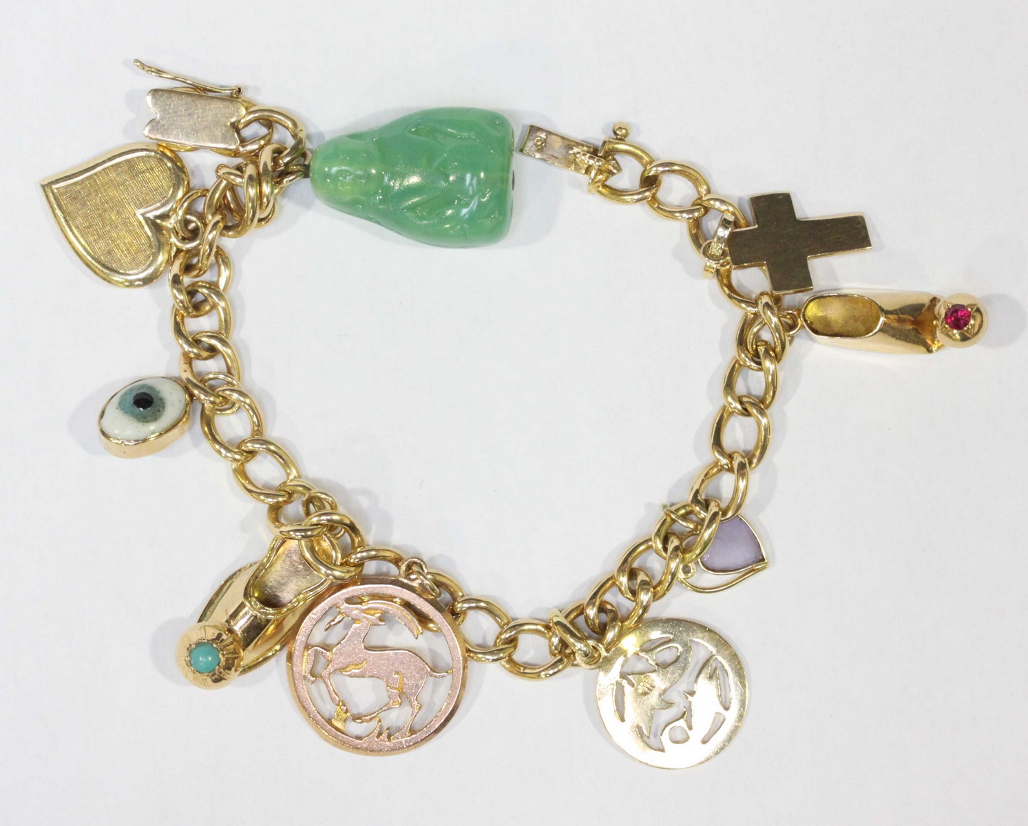 An 18ct gold charm bracelet, hung with a mixture of 18k, 14k and 9ct gold charms, total weight 36.