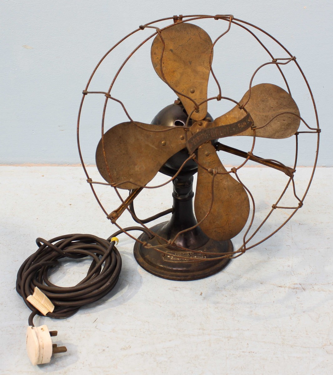 A vintage electric fan with bent wire cage and with plaque reading 'Veritys ltd.' 41cm high.