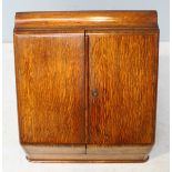 An early 20th Century oak writing compendium, the sloped front with two doors enclosing a fitted,