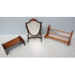 A mahogany shield-shaped swinging mirror, 47cm, together with two book cradles.