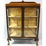 A mahogany two door display cabinet, the two glazed doors enclosing two shelves, raised on