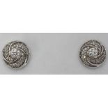 A pair of 18K white gold and diamond stud earrings, the circular-swirl settings centrally set with a