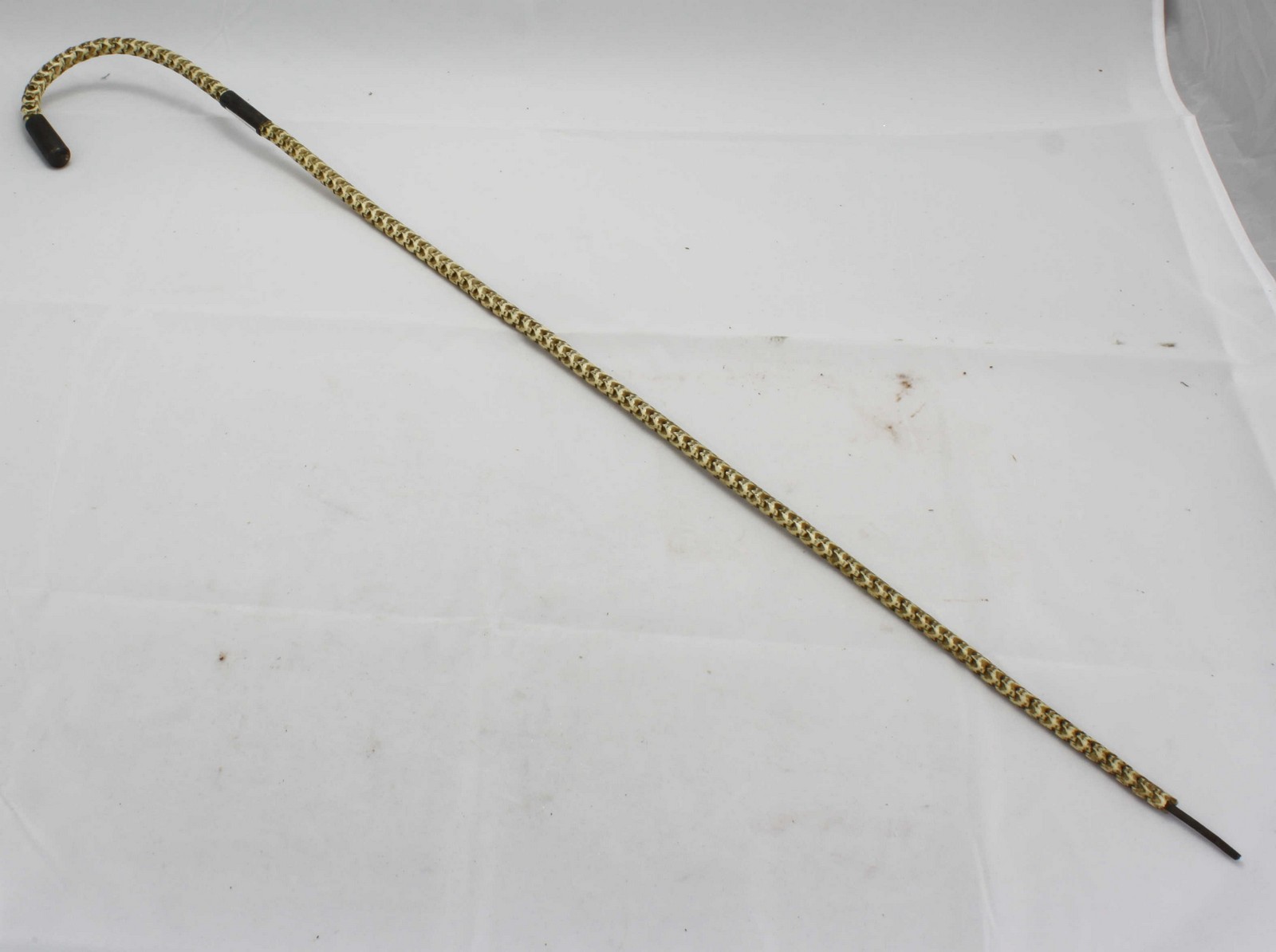 A snake or shark vertebrae walking stick with white metal detailing. (AF) 84cm.