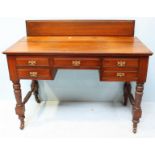 An Edwardian stained walnut writing desk, with three central, short frieze drawers above two further