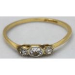 An 18ct Gold and Platinum three stone diamond ring, the oval centrally set diamond approx 0.10pts,