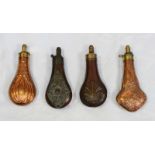 Four copper powder flasks with brass dispensers, all with embossed decoration including one with