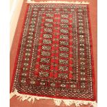 A small hand-knotted Caucasian rug, the central field decorated with twenty two geometric guls to