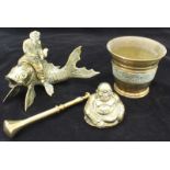 A group of four brass items, including a pestle and mortar, a standing and seated Buddha and a