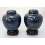 A pair of 20th century oriental cloisonné enamel lidded ginger jars with dark blue and gilt floral