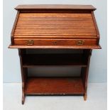 A 1920's stained oak bureau, the roll top opening to reveal pigeon holes, above an open storage