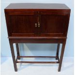 A 20th Century stained wood two-door cabinet on stand of rectangular form, the two panelled cupboard