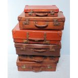 Six various vintage brown leather suitcases of varying sizes.