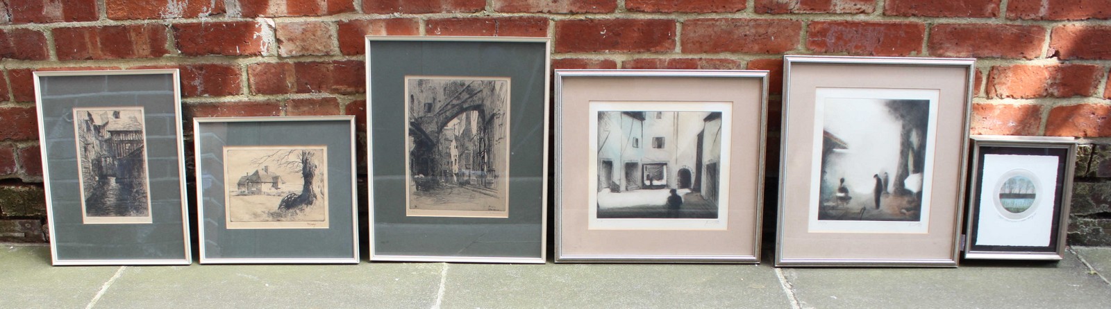 A pair of late 20th century prints of figures in courtyard, indistinctly signed, etching with