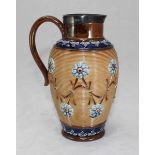 A Doulton Lambeth stoneware pottery jug with blue floral moulded decoration and a sterling silver