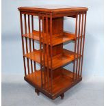 An early 20th century mahogany revolving bookcase with three segmented shelves, to quadripartite