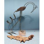 A small driftwood sculpture carved with crocodiles and similar wooden and metal stork.