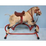 A mid-20th Century Triang metal rocking horse, with painted body, saddle and reins and supported