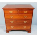 A 20th century hardwood chest of two short over three long graduated drawers with brass handles