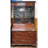 A George III inlaid mahogany bureau bookcase, the shaped cornice with dentil moulding, above a