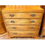 An early 19th century faded mahogany chest of four long graduated drawers with oval brass handles,