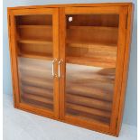 A stained wood two door hanging display cabinet, the two glazed doors enclosing seven shelves.