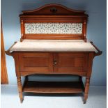 An Edwardian walnut washstand, the tile panelled back above a marble top, over two panelled cupboard