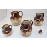 A set of five graduated Doulton Stoneware Harvest jugs, with applied figures, dogs and stag,