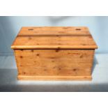 A stripped pine blanket box, the hinged top opening to reveal storage space, with painted handles to