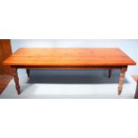 A large pine table, with plain, varnished top, plain frieze and raised on shaped and turned