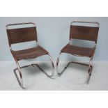 A pair of cantilever chairs with bent, polished chrome frames and grey, stretched leather backs