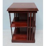 An Edwardian mahogany bookcase, with inlaid top, over two segmented shelves, slatted sides and